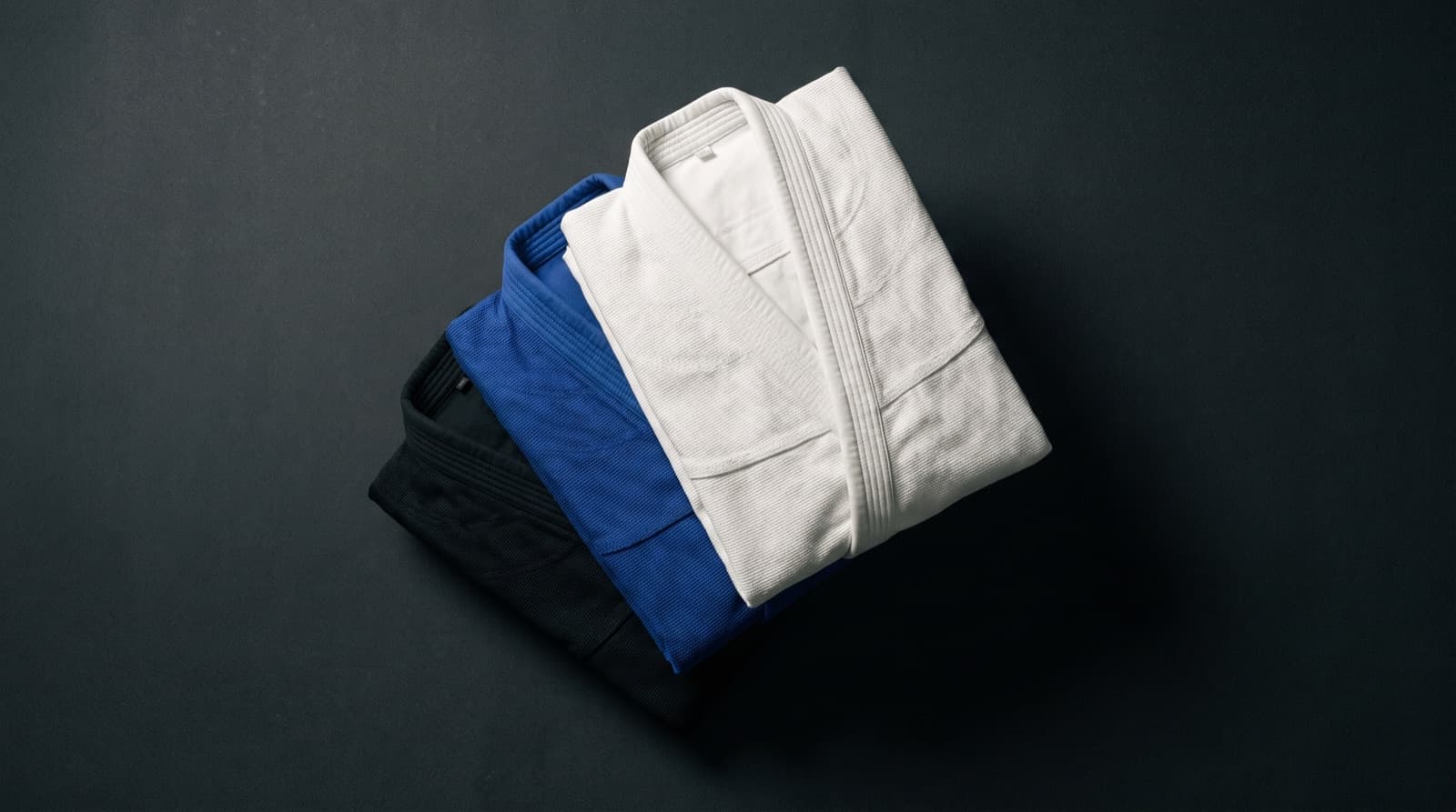BJJ gis in several sizes folded and stacked