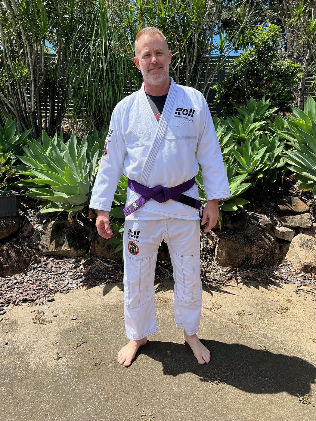 Ibuprofen Top Team gi worn outdoors with a purple belt